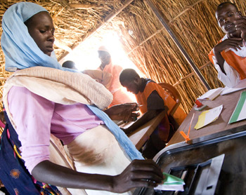 Un votante en el campamento de desplazados internos de Zam Zam (Darfur septentrional) presenta su papeleta en el primer día de las elecciones nacionales de Sudán.