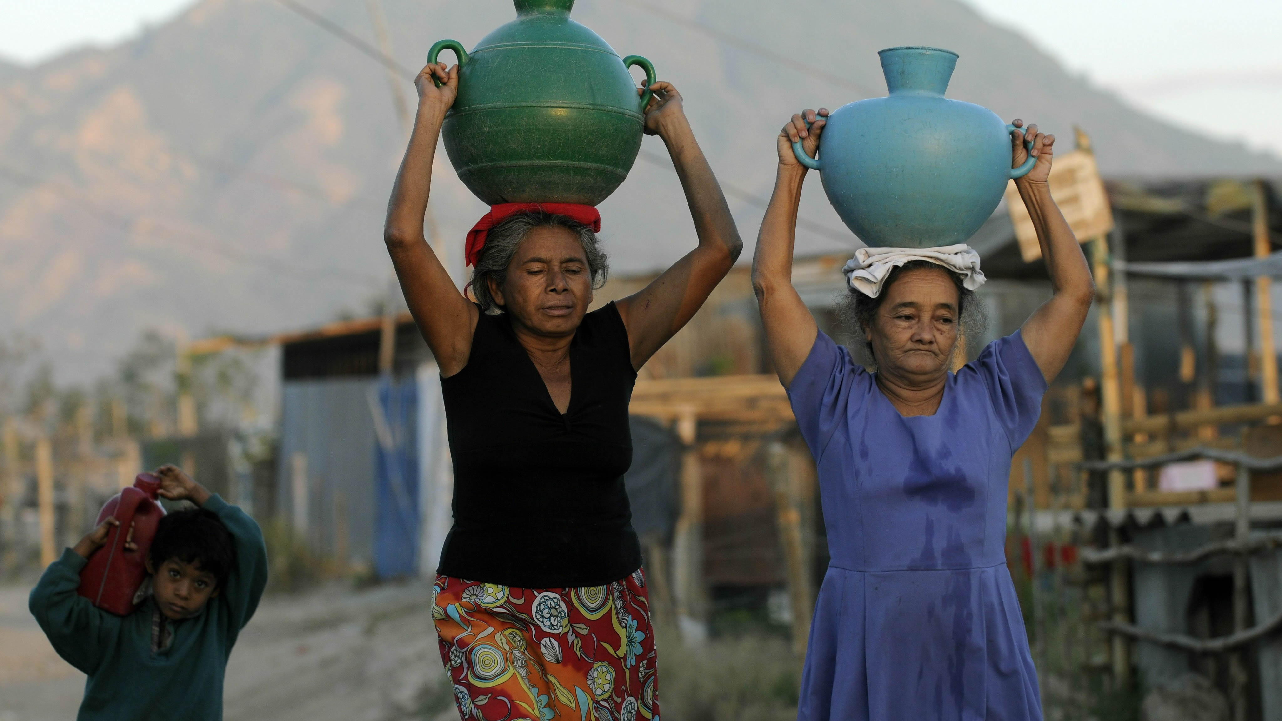 Foto de dos mujeres llevando una vasija en la cabeza