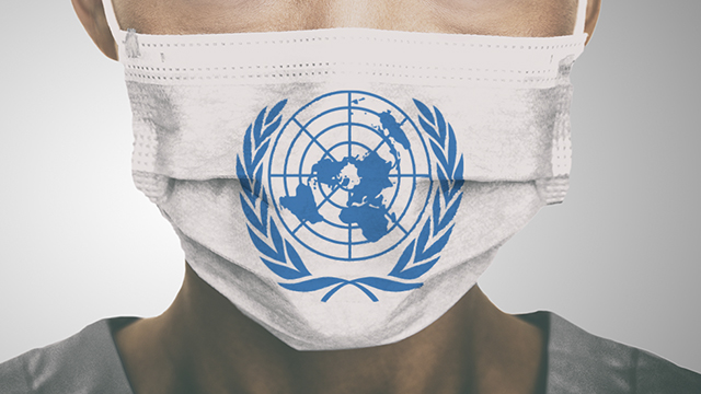Personal hospitalario con máscara donde está emplazado el logo de las Naciones Unidas. 