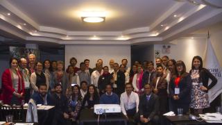 Reunión de participantes sonriendo en la sala de talleres